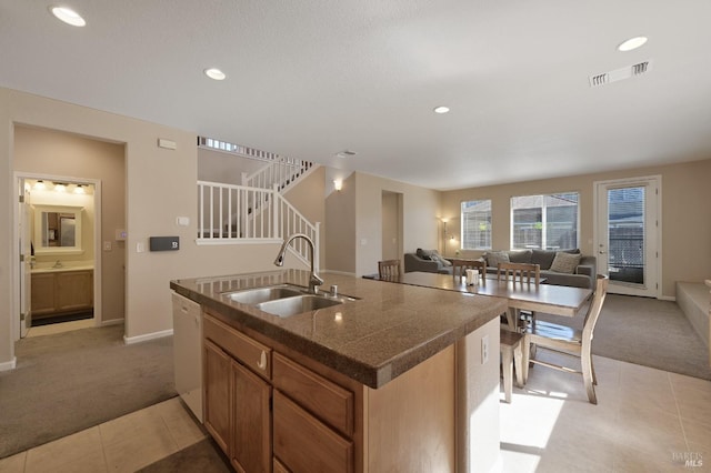 kitchen featuring a sink, light tile patterned floors, light colored carpet, and visible vents