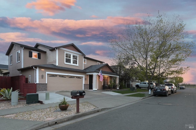 craftsman-style house featuring brick siding, fence, a garage, and concrete driveway