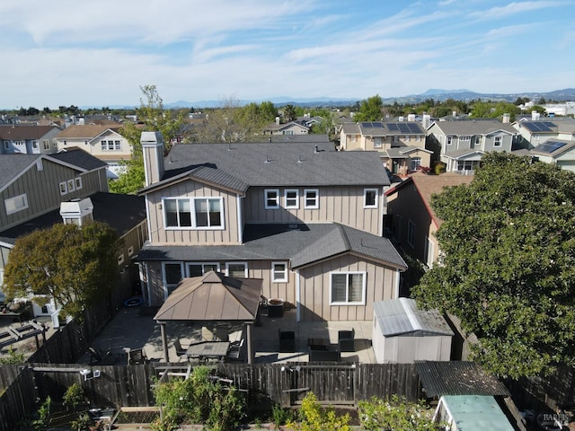 back of house featuring a residential view, a fenced backyard, and board and batten siding