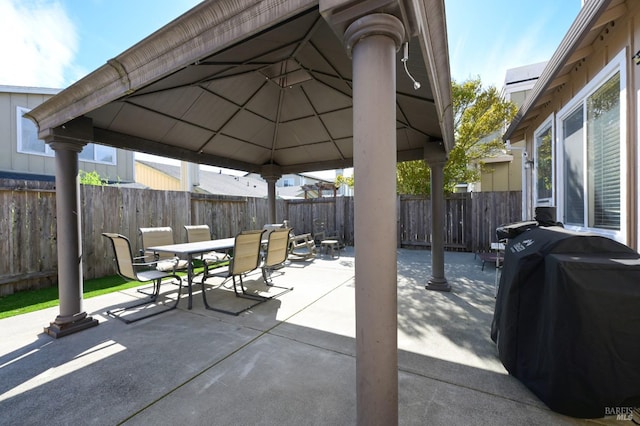 view of patio featuring outdoor dining space, a gazebo, grilling area, and fence