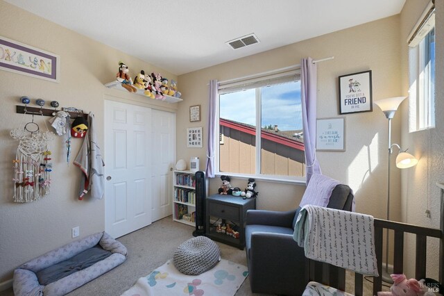 carpeted bedroom featuring visible vents and a closet