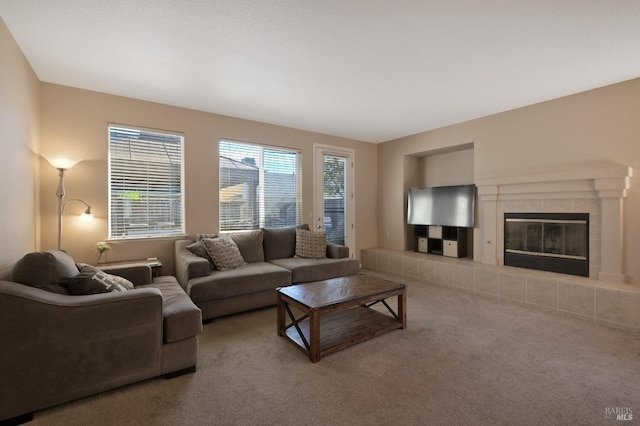 living room with a tiled fireplace and carpet flooring