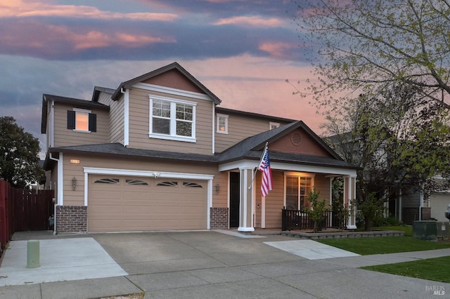 craftsman-style home with concrete driveway, fence, a garage, and covered porch