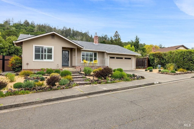 ranch-style home featuring an attached garage, a chimney, fence, and concrete driveway