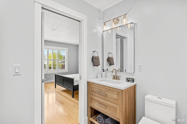 bathroom featuring toilet, vanity, and wood finished floors
