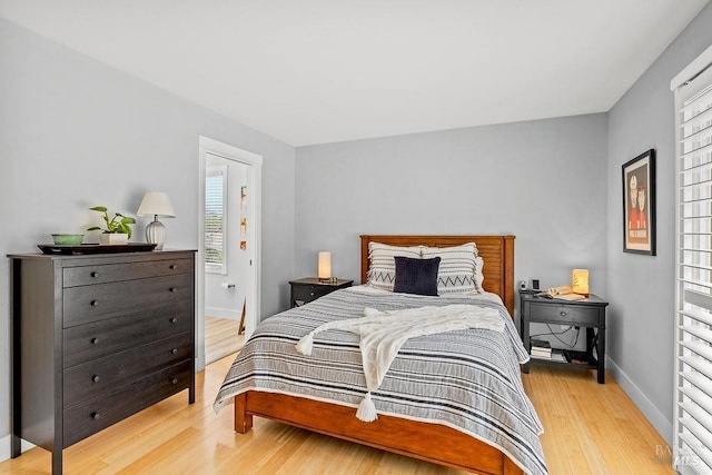 bedroom with light wood-type flooring and baseboards