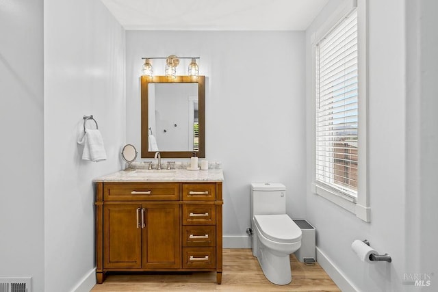 bathroom with a wealth of natural light, wood finished floors, and visible vents