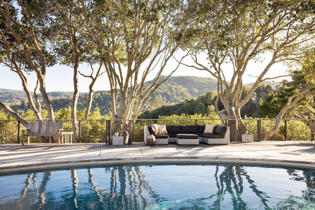 view of pool featuring an outdoor living space, a patio, a mountain view, and a fenced in pool