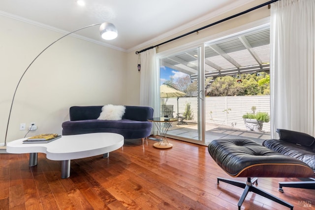 living area featuring ornamental molding, a wealth of natural light, and hardwood / wood-style floors