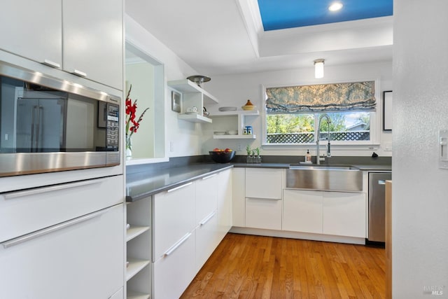kitchen featuring open shelves, modern cabinets, white cabinetry, a sink, and stainless steel appliances