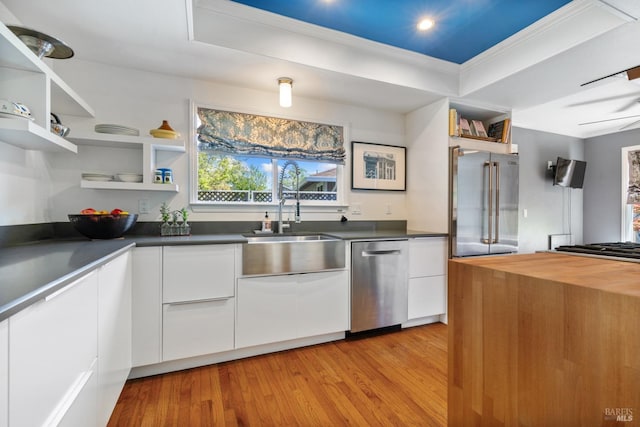 kitchen featuring open shelves, a sink, and white cabinetry