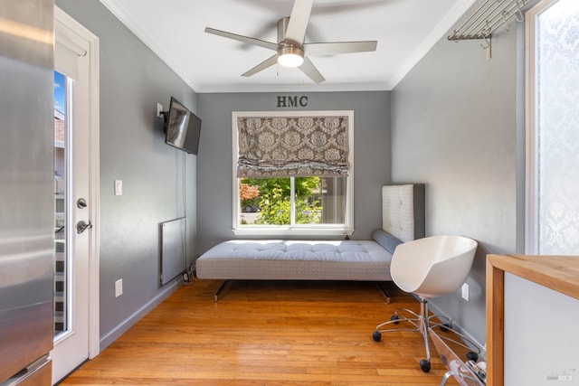 interior space with ceiling fan, ornamental molding, baseboards, and light wood-type flooring