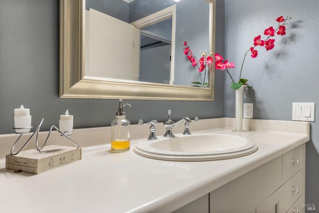 bathroom with a textured wall and vanity