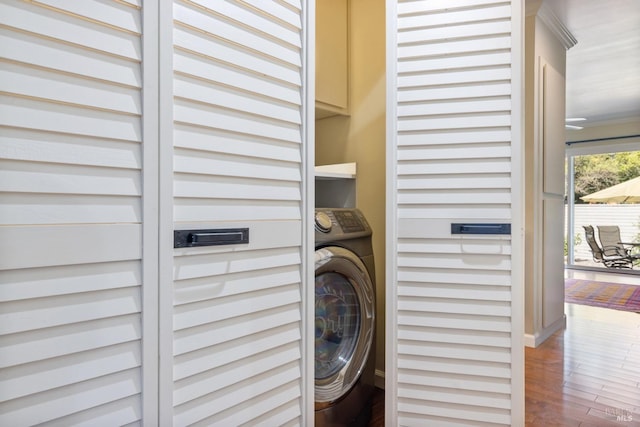 washroom featuring laundry area, baseboards, washer / clothes dryer, and wood finished floors