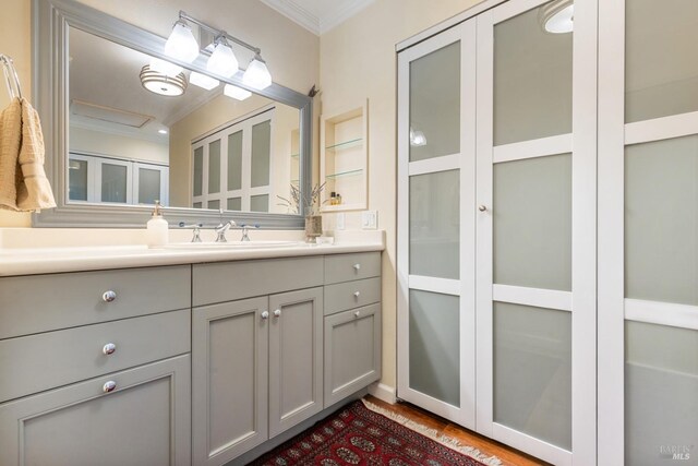 bathroom featuring crown molding, vanity, and wood finished floors