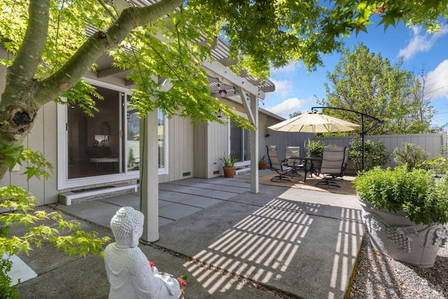 view of patio featuring outdoor dining area, fence, and a pergola