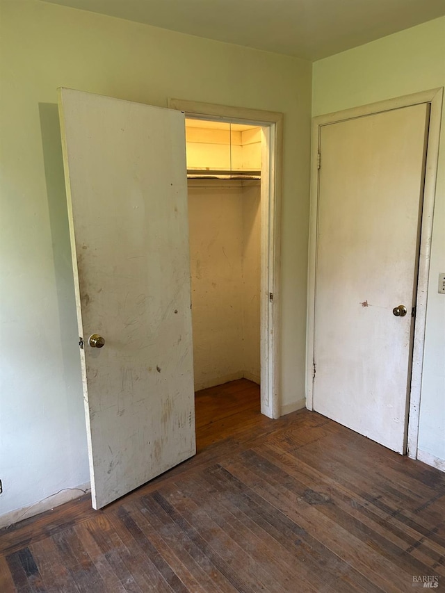 unfurnished bedroom with hardwood / wood-style flooring and a closet