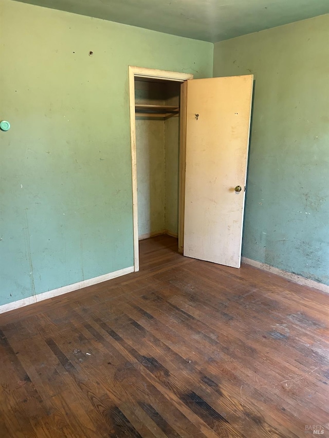 unfurnished bedroom featuring hardwood / wood-style floors and a closet