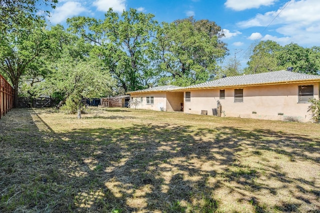 back of house with stucco siding and fence