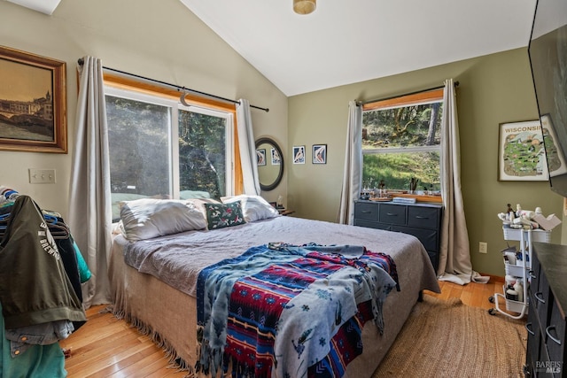 bedroom with light wood-type flooring and vaulted ceiling