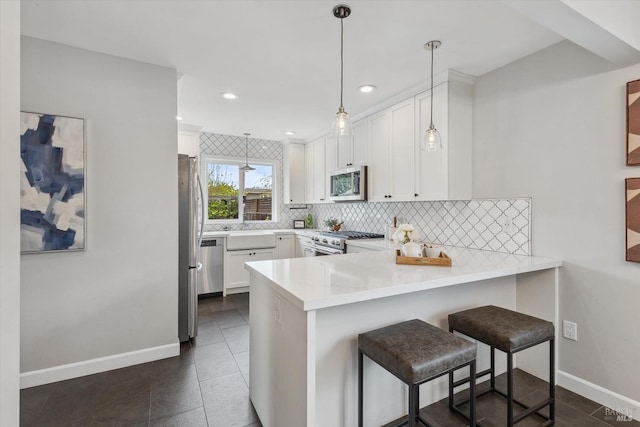 705 5th St, Petaluma, CA 94952 - kitchen with a peninsula, white cabinetry, appliances with stainless steel finishes, decorative backsplash, and baseboards