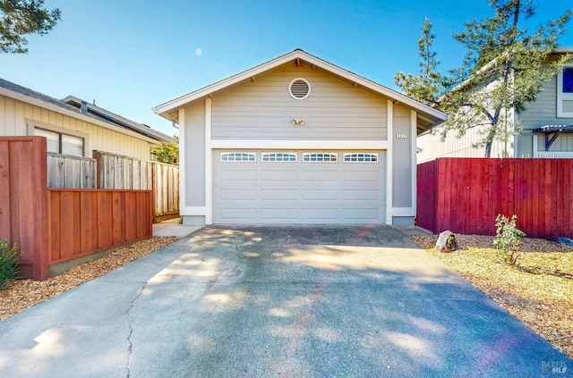 view of front facade featuring an outbuilding, driveway, fence, and a garage