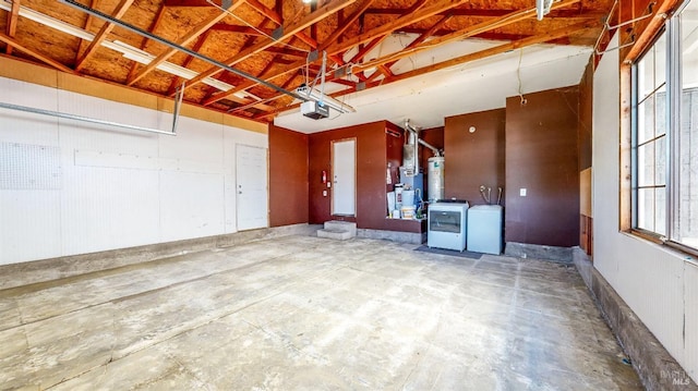 garage with a garage door opener, separate washer and dryer, and water heater