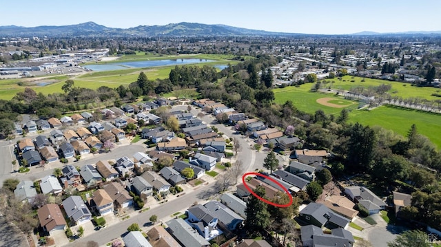 aerial view featuring golf course view, a water and mountain view, and a residential view