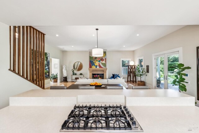 999 Pratt Ave, Saint Helena, CA 94574 - kitchen with decorative light fixtures, light countertops, recessed lighting, stainless steel gas stovetop, and a lit fireplace