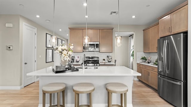 3916 Valance Way, Rancho Cordova, CA 95742 - kitchen with stainless steel appliances, decorative backsplash, light wood-type flooring, a breakfast bar, and light countertops