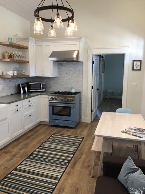 9123 Red Hill Ct, Cotati, CA 94931 - kitchen featuring extractor fan, appliances with stainless steel finishes, white cabinets, tasteful backsplash, and vaulted ceiling