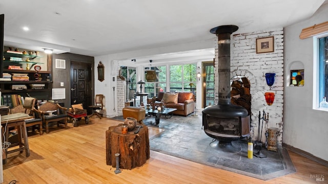 living room with wood finished floors and a wood stove