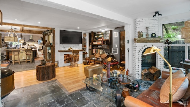 living area with wood finished floors, a fireplace, visible vents, and recessed lighting