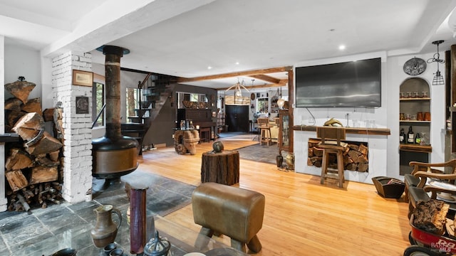 living area featuring a wood stove, recessed lighting, wood finished floors, and stairs
