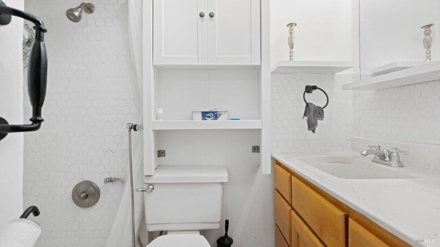 bathroom featuring tasteful backsplash, vanity, and toilet