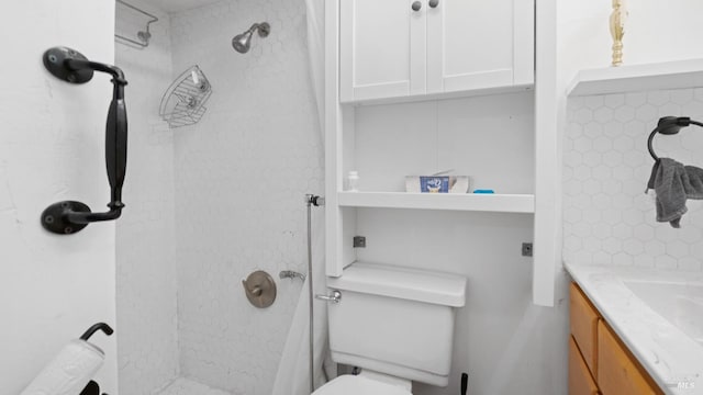 bathroom with a shower, vanity, and toilet