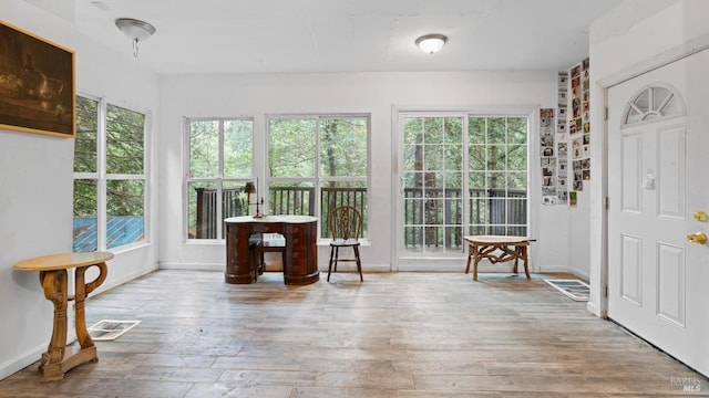 sunroom with visible vents, wood-type flooring, and baseboards