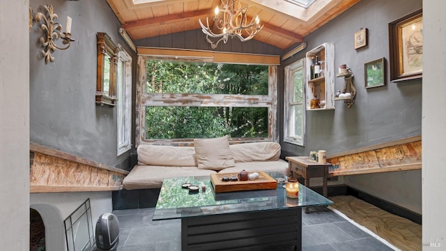 sunroom with beamed ceiling, a skylight, an inviting chandelier, and a healthy amount of sunlight