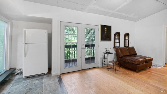 living area featuring french doors, wood finished floors, and visible vents