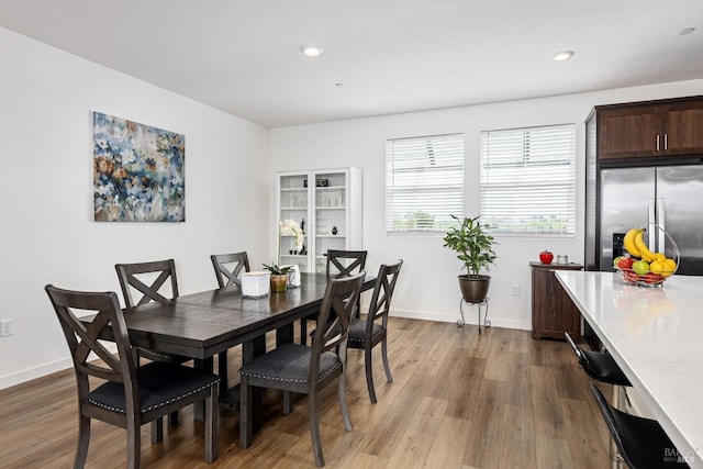 dining room with recessed lighting, baseboards, and wood finished floors