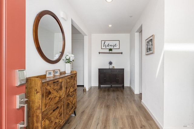 corridor with recessed lighting, baseboards, and wood finished floors