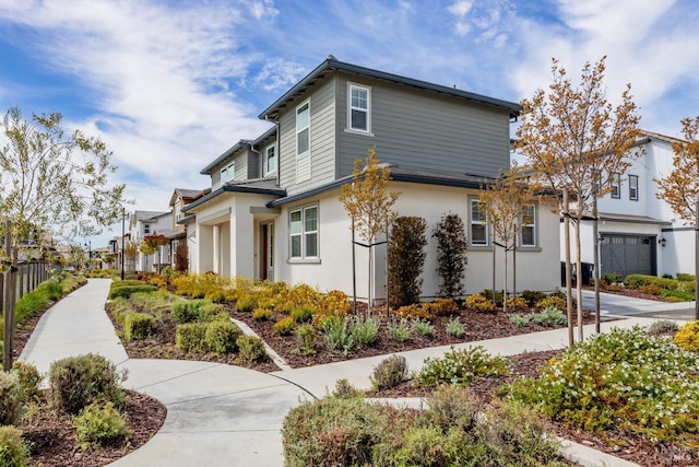 view of front of property with stucco siding, fence, and a residential view