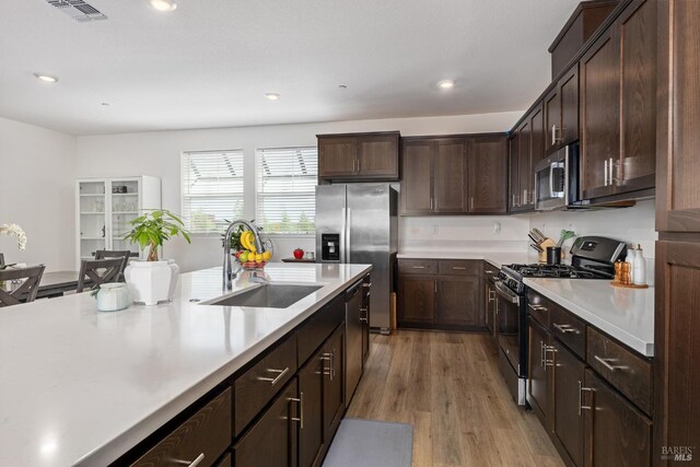kitchen featuring visible vents, light wood-style floors, light countertops, a sink, and appliances with stainless steel finishes