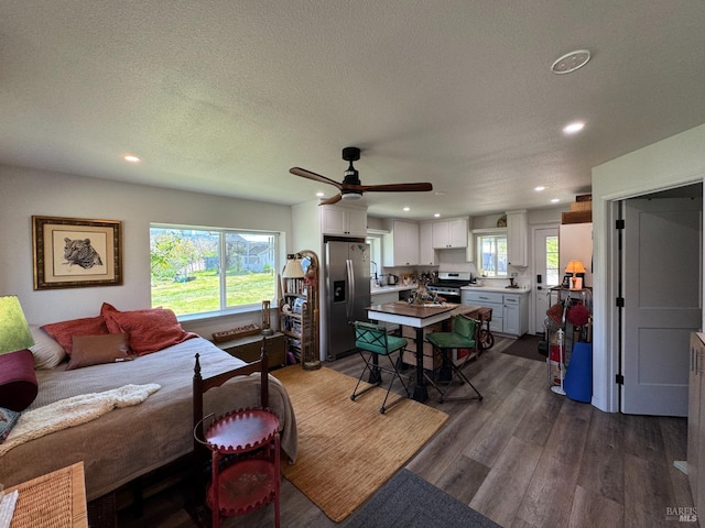 bedroom with stainless steel fridge with ice dispenser, recessed lighting, dark wood-style flooring, and a textured ceiling