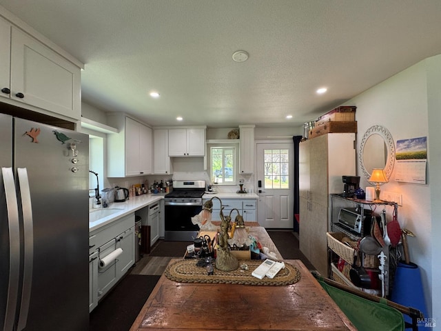 kitchen with dark wood-style flooring, recessed lighting, white cabinets, appliances with stainless steel finishes, and a sink