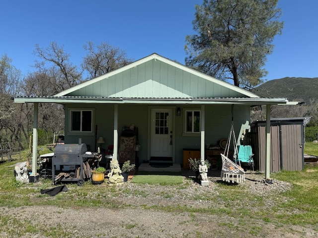 back of property with entry steps and a mountain view
