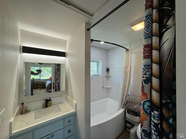 bathroom featuring shower / tub combo with curtain, vanity, a textured ceiling, and a healthy amount of sunlight