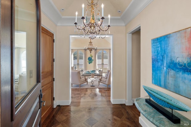 entryway featuring a notable chandelier, ornamental molding, and a healthy amount of sunlight