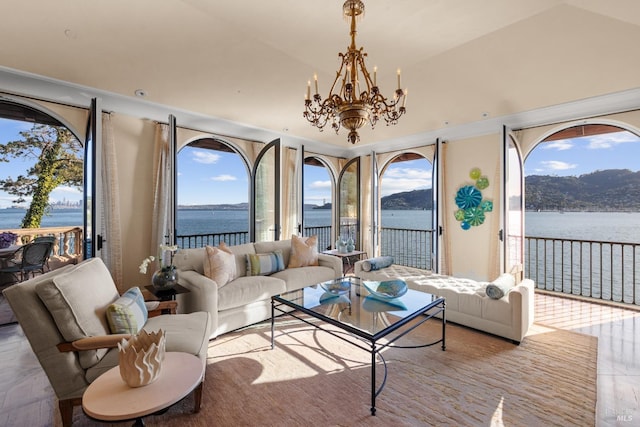 sunroom / solarium with a notable chandelier, a water view, and a healthy amount of sunlight