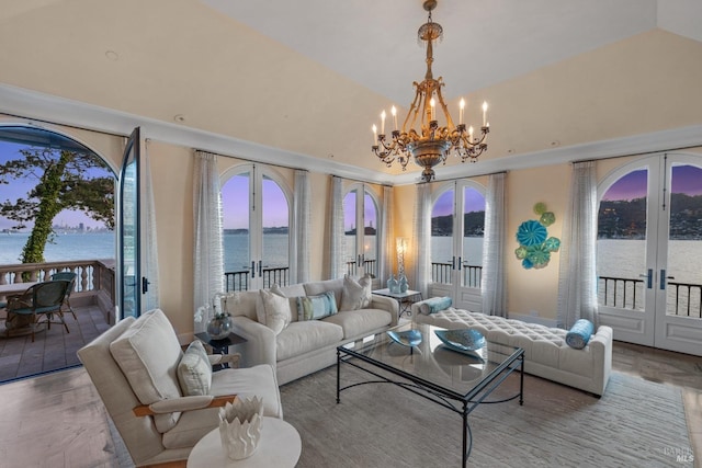 living room with lofted ceiling, french doors, a chandelier, and a water view